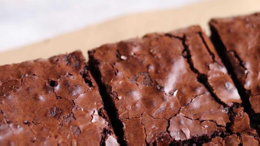 Close-up video of freshly baked brownie cubes, highlighting their crumbly crust and rich interior. The focus is on texture and the irresistible allure of this classic treat Royalty-Free Stock Footage #1108015489