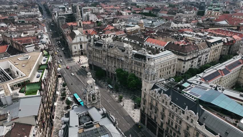 The drone is flying towards the Királyi Bérpalota castle with a busy road in front of it in Budapest Hungary Aerial Footage 4K