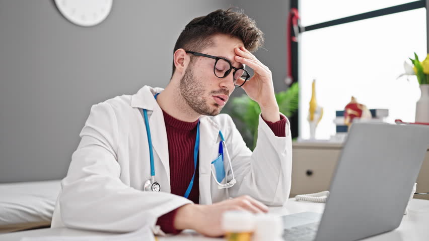 Young hispanic man doctor taking glasses off stressed at clinic Royalty-Free Stock Footage #1108023197
