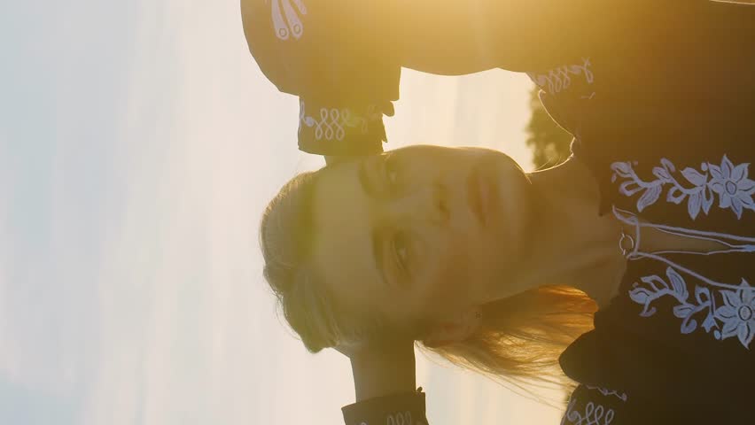 Vertical Portrait of gorgeous young woman standing in gold wheat field glowing sunset rays