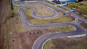 Aerial 4k footage of a karting race track. Drone shot of a Kart Circuit. Short circuit karting racing seen from above. High angle video of carts racing on a track.