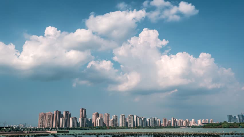 Time lapse cityscape at daytime blue sky, clouds pass over downtown multistorey buildings, lake and bridge, Suzhou Indusrtial park, China