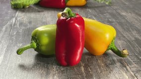 Video of colorful bell peppers on wet table in fine mist and changing light