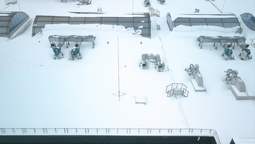 Flying over the roof of a shopping mall as workers check snow-covered engineering equipment in winter Royalty-Free Stock Footage #1108031531