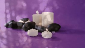 Animation of white light spots over lit candles and stones. Lifestyle and wellbeing concept digitally generated video.