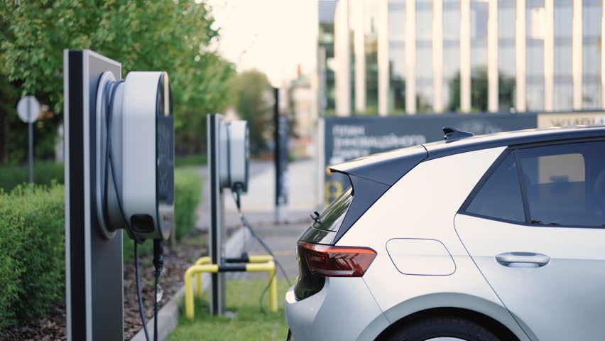 Charge station for electric cars. Electric car charger. Alternative energy for ecological cars. Electric, zero pollution cars on green energy concept on modern city parking lot. Royalty-Free Stock Footage #1108035371