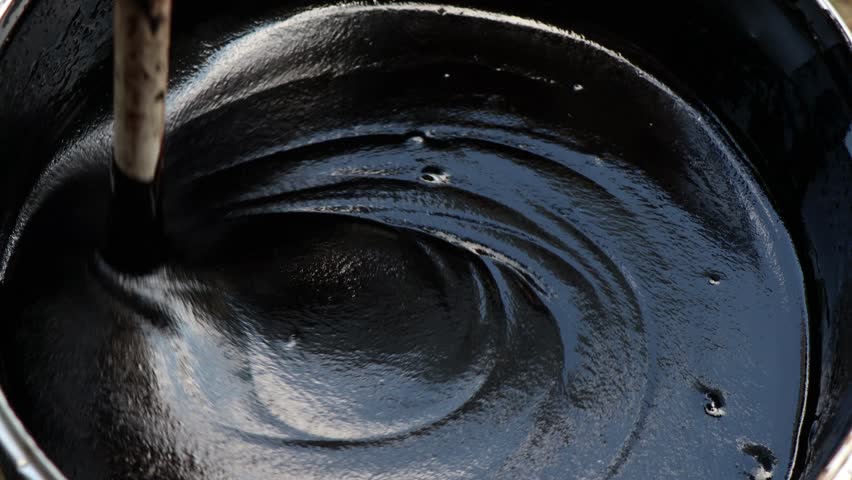 Black bitumen mastic oily liquid is stirred in a bucket (capacity) before waterproofing Royalty-Free Stock Footage #1108055703