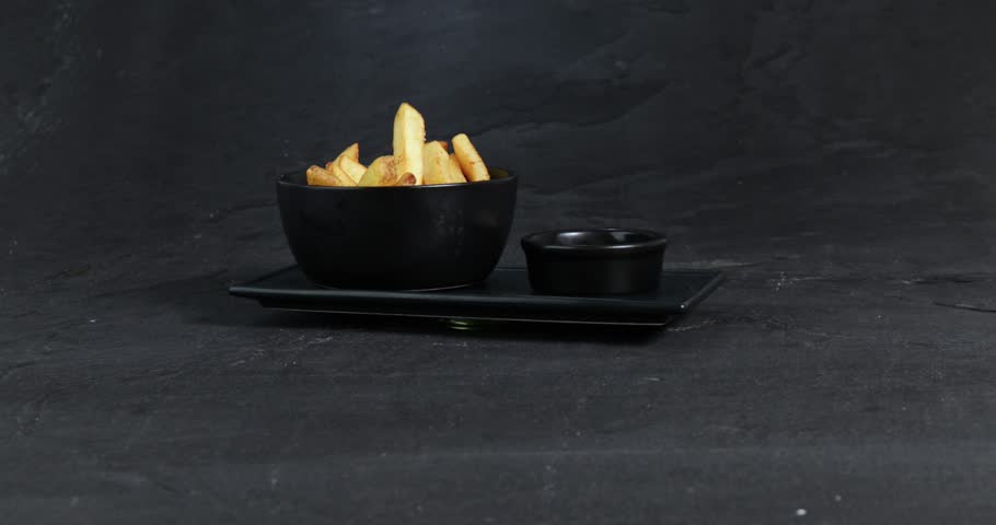 French fries with salt next to a mug of mayonnaise are presented on a rotating plate (spin + camera moving). Royalty-Free Stock Footage #1108060927