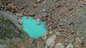 Small turquoise glacial lake in Valmalenco valley of Valtellina in summer season, Northern Italy. Aerial drone view