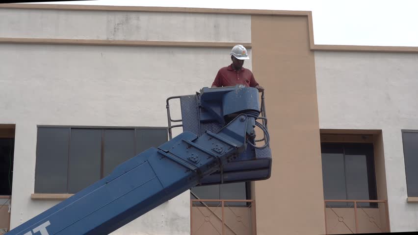 Worker uses the hydraulic lifting system to elevate the boom lift for goods Royalty-Free Stock Footage #1108065209