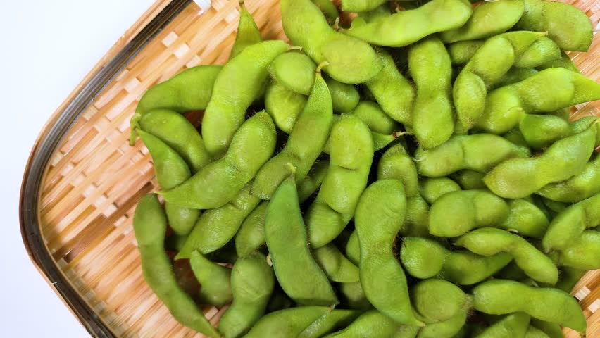 Edamame, boiled green soybeans on a bamboo colander rotating Royalty-Free Stock Footage #1108066659