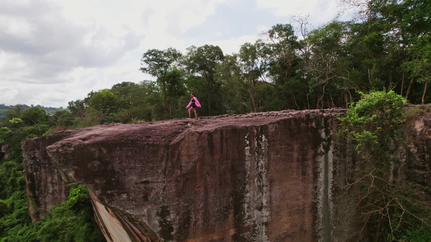 A woman confidently approaches the cliff