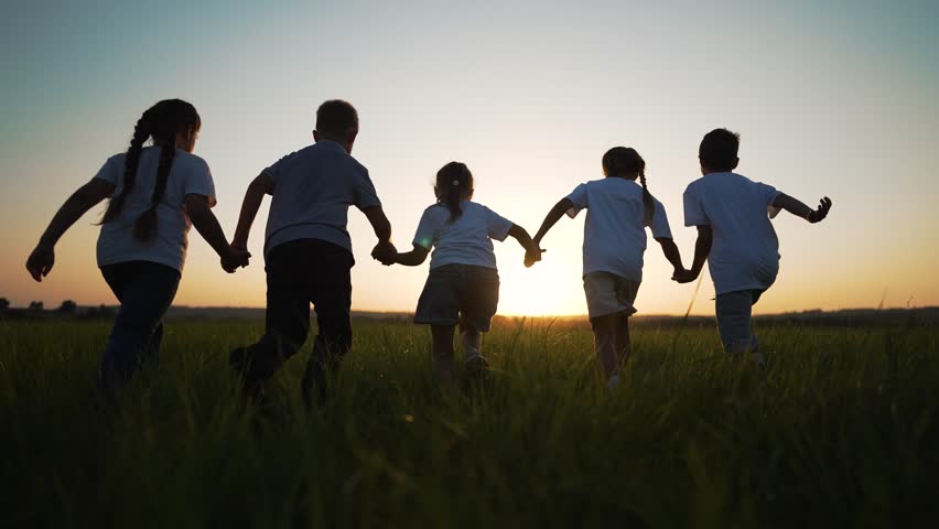 happy family. Child run at sunset in summer. group of kid team run together on green field. Child play have fun together in team outdoors in park. Summer recreation of kid in park on grass. Kid dream Royalty-Free Stock Footage #1108073077