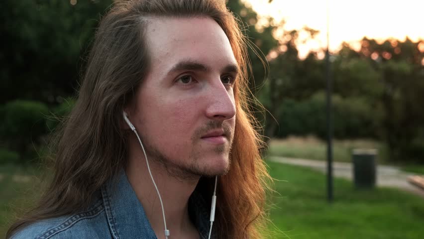 Young man with headphones smoking e-cigarette and drinking coffee outdoor at evening | Shutterstock HD Video #1108076843