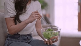 Lifestyle in living room concept, Young vegetarian Asian woman eating vegetable salad, healthy eating concept. - Powered by Shutterstock - Get 15% off with code: PIKWIZARD15