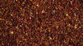 Dried crushed pepper Gochugaru, close-up. Medium-ground red dry pepper uses in Korean cuisine for kimchi, gochujang and other savory dishes. Popular spicy condiments. 4K video, Rotating.