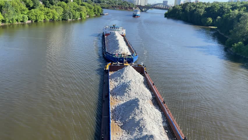 Aerial view. The barge floats on a wide river loaded with rubble. Delivery of raw materials by water. The bulk carrier transports gravel on a navigable river Royalty-Free Stock Footage #1108083753