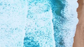 Waves sea water surface High quality video Bird's eye view, Drone top view waves crashing on sand beach,Nature ocean sea beach background