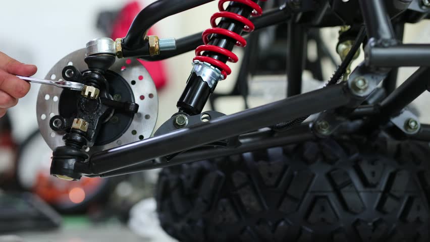 Workers are making a motorcycle in the workshop. Preparing the ATV for sale
