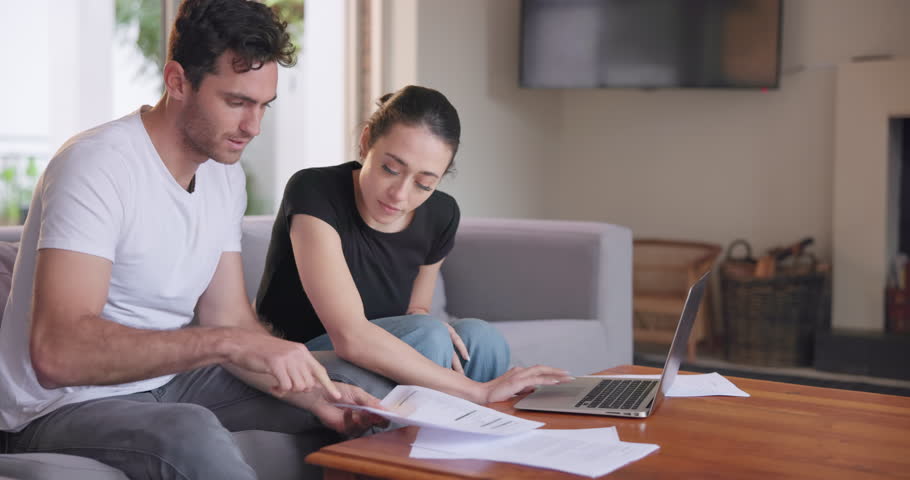 Couple, documents and laptop on sofa for budget, investment planning or home administration. Man, woman and paperwork at computer for savings, taxes and online banking for loan, insurance or mortgage Royalty-Free Stock Footage #1108090113