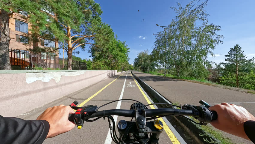 POV Electric Bike Riding on a Bike Path near the River Embankment at Sunny Day. 60 fps, H.264, 8bit, chroma subsamlping 4:4:4