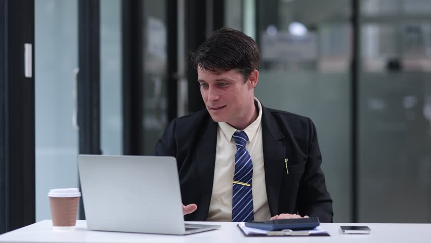 Success and excited man with laptop sitting in creative office, Excited businessman winner, celebrate winning. 