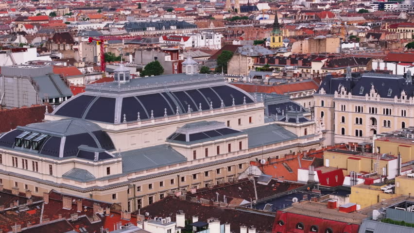 Hungarian State Opera. Large historic building with majestic roof and lookout terrace. Surrounding town development in background. Budapest, Hungary