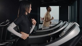 Motivated sport people runners cardio exercise on treadmills active workout at fitness club multiracial couple athletes running sprint jog in dark gym sportsman and sportswoman run healthy lifestyle - Powered by Shutterstock - Get 15% off with code: PIKWIZARD15