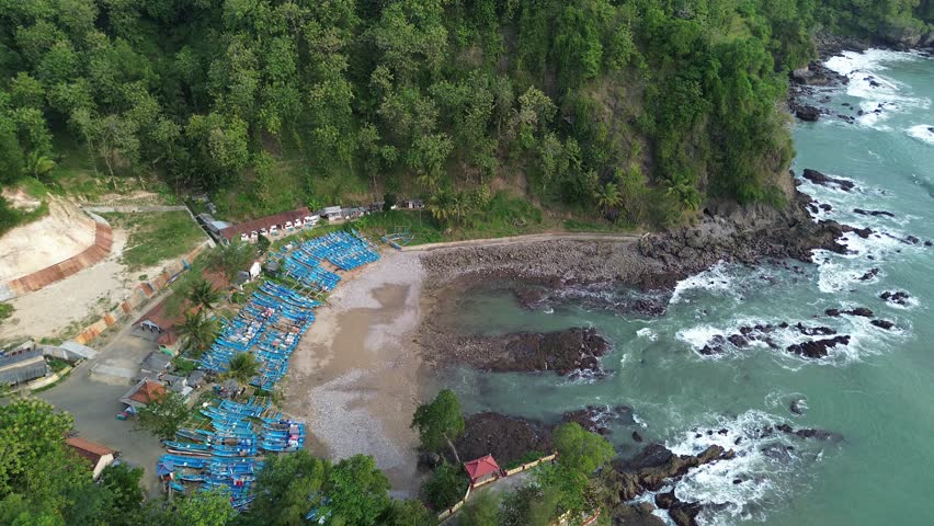 Beautiful Beach with cliffs and calm waves and traditional fishing boats that are leaning