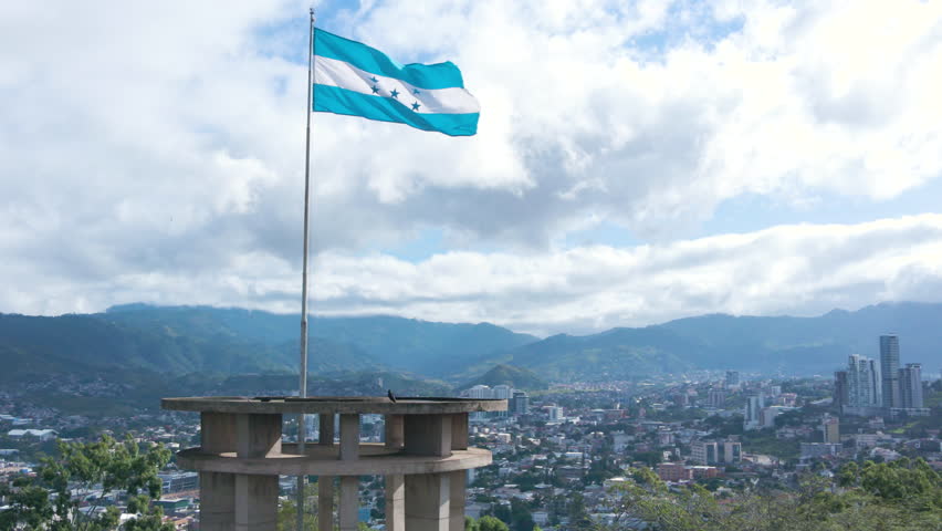 Aerial circling over the flag of Honduras and with a parallax effect with Tegucigalpa City as background  Royalty-Free Stock Footage #1108113423