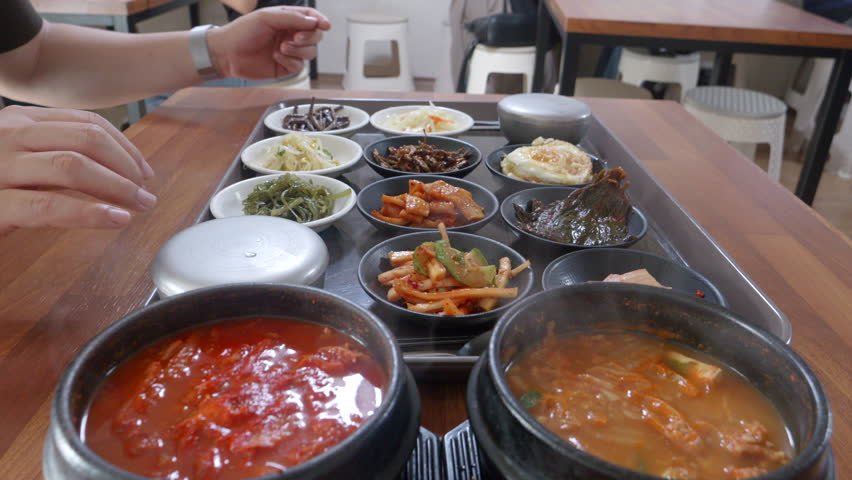 Eating Korean food with lots of side dishes, kimchi stew, and cheonggukjang Royalty-Free Stock Footage #1108113805