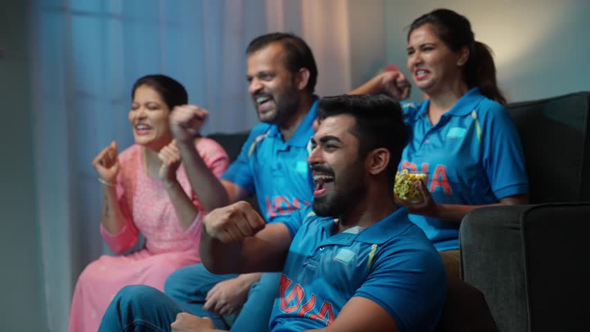Side view shot of Group of family member shouting as India to support Indian Cricket Team while watching on tv at home - concept of Energetic fans, Cheering Family and Team Spirit. Royalty-Free Stock Footage #1108116059