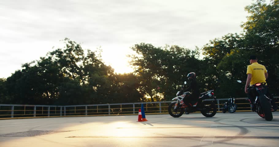 Filming of a biker instructor and a biker student in a driving school. Learning to drive a motorcycle at a motorcycle school Royalty-Free Stock Footage #1108117069