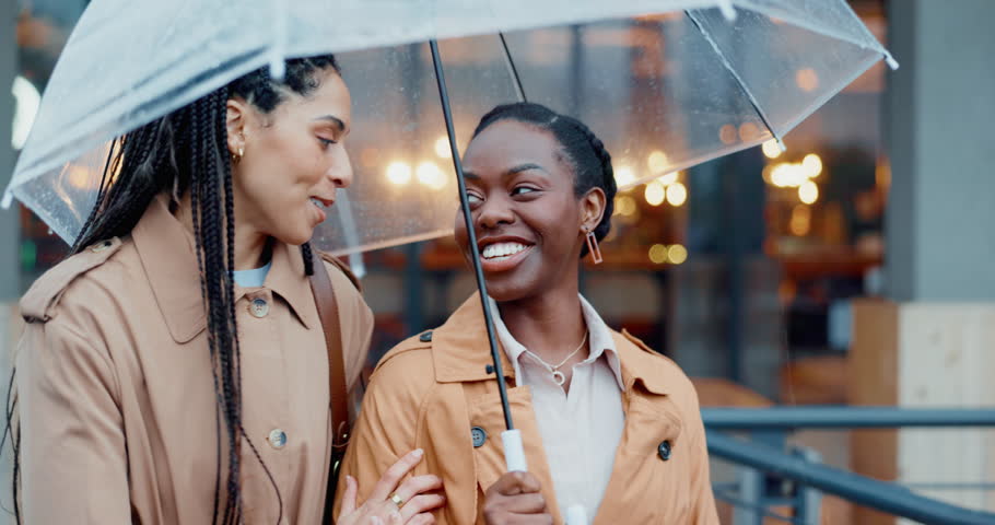 Women, travel and city with umbrella and friends, insurance and rain with smile and talking outdoor. Commute, journey to work and wet winter weather, urban street and professional with security