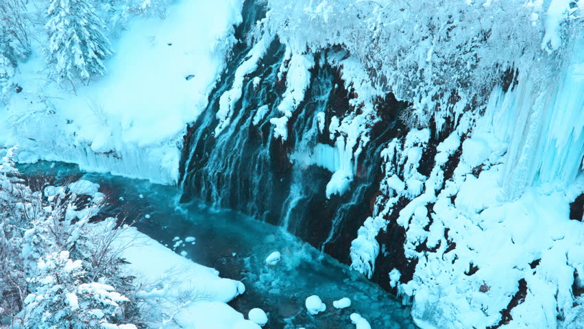 Shirahige Waterfall with Snow in winter, Biei river flow into Blue Pond. landmark and popular for attractions in Hokkaido, Japan. Travel and Vacation concept