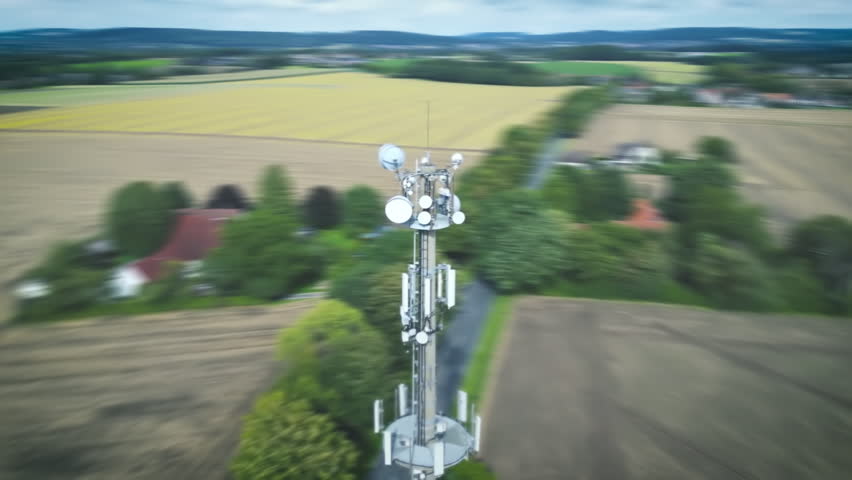 Antenna tower in landscape with isolated houses transmits strong communication waves signals. Drone shot, concept modern data transmission Royalty-Free Stock Footage #1108126299