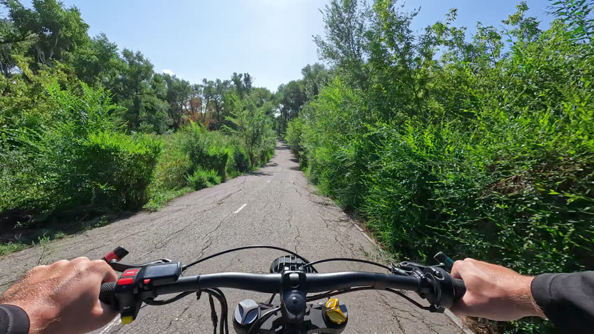 POV Electric Bike Riding Up and then Down on Asphalted Bike Path Hill in the Forest at Sunny Day. 60 fps, H.264, 8bit, chroma subsamlping 4:4:4