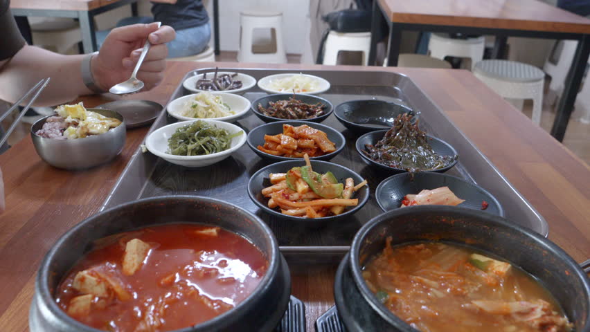 Eating Korean food with lots of side dishes, kimchi stew, and cheonggukjang Royalty-Free Stock Footage #1108129925