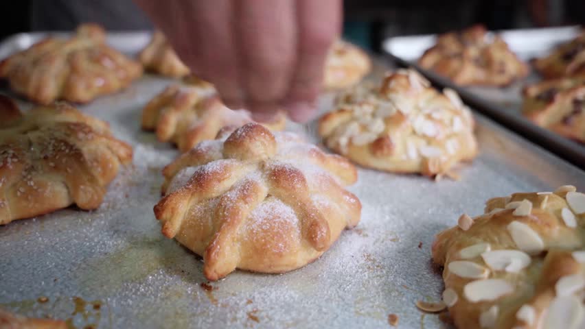 A young Hispanic baker is covering a Day of the Dead bread with sugar Royalty-Free Stock Footage #1108131683