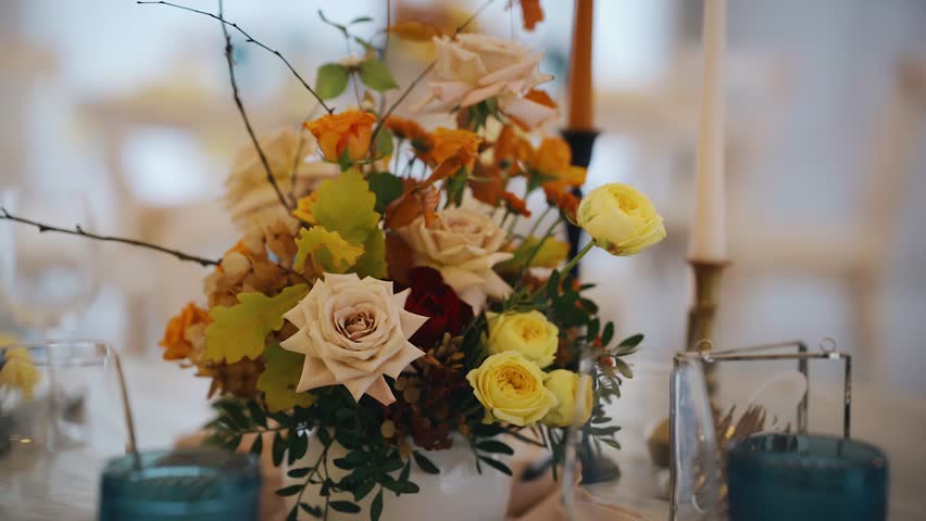 There is a beautiful decoration of flowers and other decor on the table. Close-up shooting Royalty-Free Stock Footage #1108132399