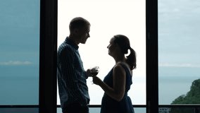 Young Caucasian couple clinking glasses of wine while resting on a balcony of hotel over beautiful sea view - Powered by Shutterstock - Get 15% off with code: PIKWIZARD15
