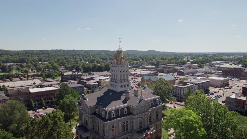 Aerial view and drone shot of clocktower government tower and building structure in the center of Newark, Ohio east of Columbus, OH with downtown buildings, small businesses, and residential district.