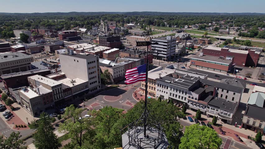 Aerial view and drone shot of clocktower government tower and building structure in the center of Newark, Ohio east of Columbus, OH with downtown buildings, small businesses, and residential district.