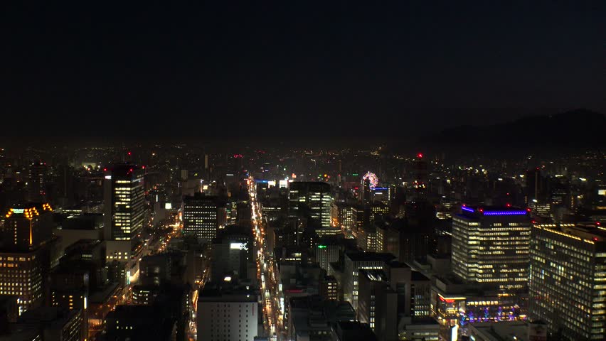 SAPPORO, HOKKAIDO, JAPAN : Aerial high angle sunrise view of cityscape of Sapporo city. View of buildings and street traffic around Susukino downtown area. 4K time lapse shot, night to morning.