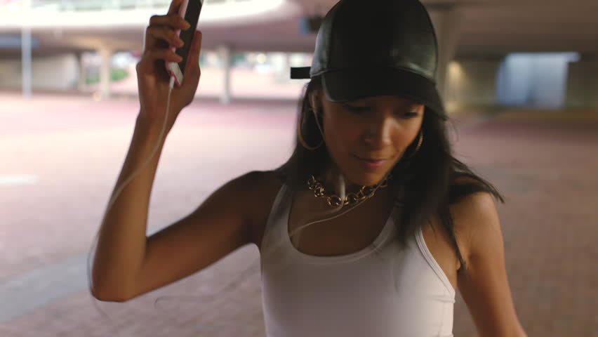 Dance, music and hip hop with woman and earphones in urban city for freedom, fitness and creative. Motivation, fashion and wellness with young girl dancing while listening to audio for street style