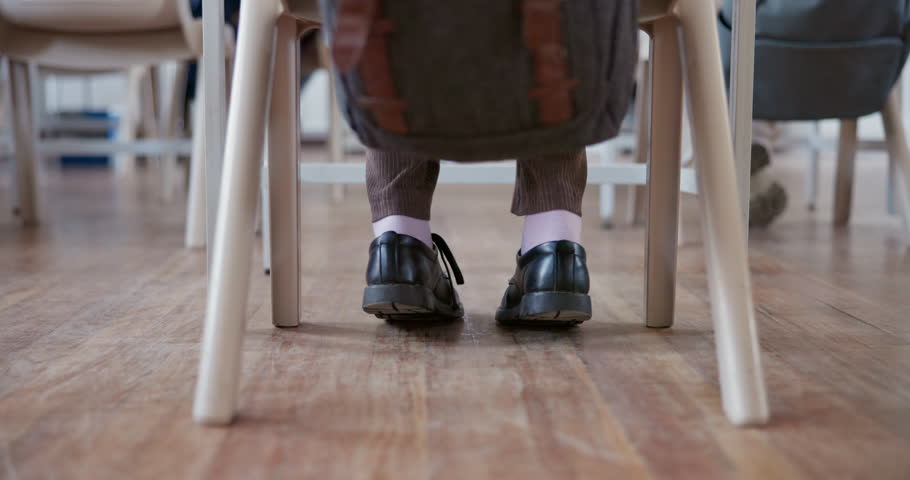 Floor, class and feet of a student with anxiety, exam stress or adhd while learning. Restless, low and a child or teenager at a desk with a nervous leg for a test, education or studying at a school Royalty-Free Stock Footage #1108137987