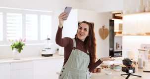 Phone selfie, talking influencer and woman cooking, live streaming and presentation of home food, recipe or baking. Kitchen video call, cellphone communication and chef filming social media broadcast