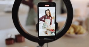 Influencer woman, cooking and phone screen for recording, ring light or live stream for web tutorial in house. Girl, chef and smartphone in home kitchen, video and stir bowl for food on social media