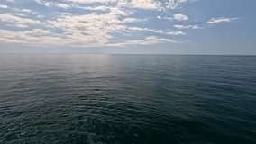 Sea water surface. Aerial view on calm water surface, camera flies over clear sea ocean. Sun glare. Abstract nautical summer ocean nature. Holiday and travel. Weather and climate change. Slow motion