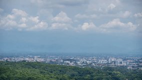 CHIANG MAI , THAILAND - SEP 2023 : clouds moving through blue sky over chiang mai city in mountainous scenery, time lapse.